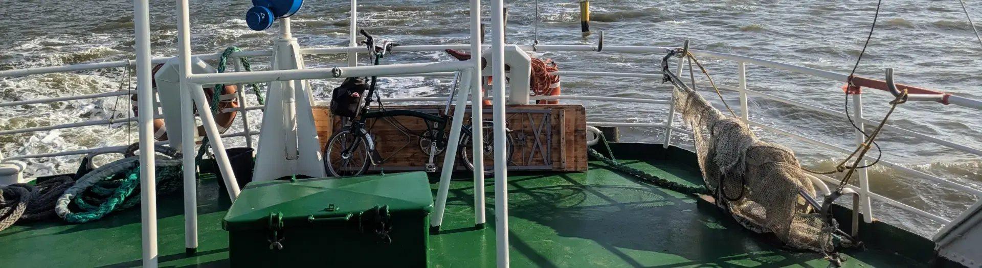 Brompton-Touring: Rund um den Jadebusen Ein grünes Brompton Faltrad auf der Fähre von Eckwarderhörne nach Wilhelmshaven