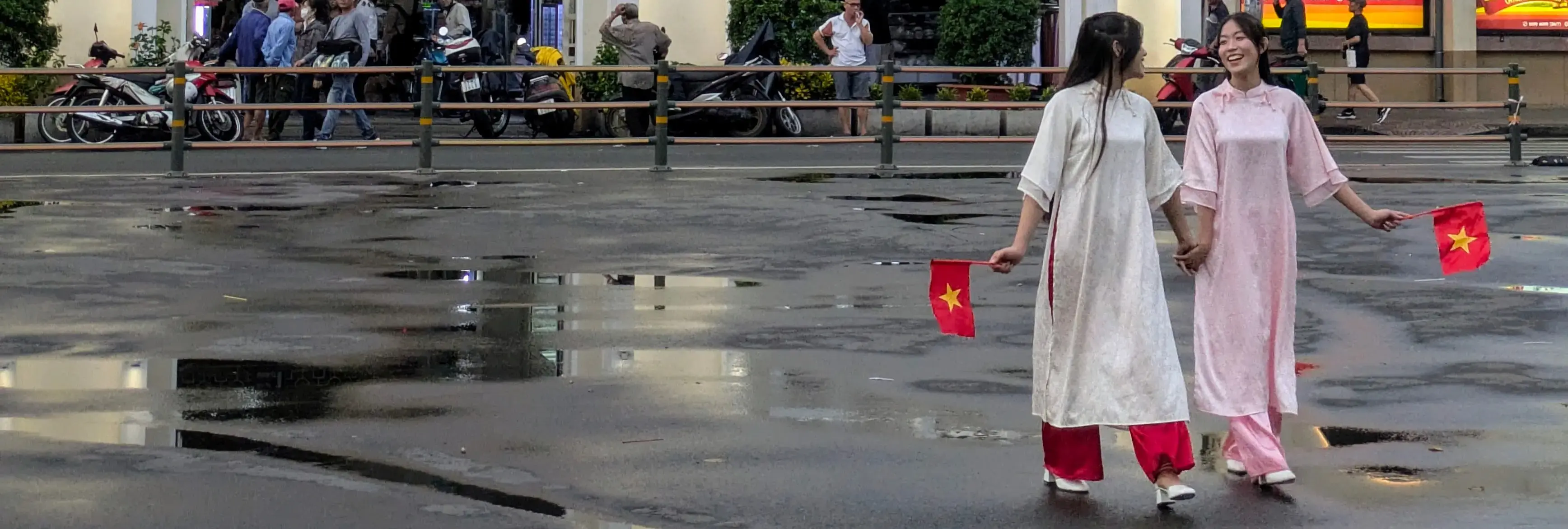 Zwei junge Frauen mit traditionellen Gewändern und kleine roten Flaggen des Staates Vietnam Zwei junge Frauen mit traditionellen Gewändern und kleine roten Flaggen des Staates Vietnam